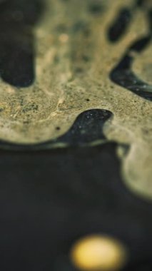 Dikey video. Sıvı jel. Bulanık serum emülsiyonu. Odaklanamayan sarı renkli parlak parlak yapışkan desenli yağ sızıntısı soyut sanat arka planında yüzen boya boya mürekkebi karışımı.