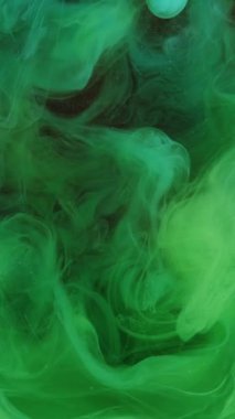 Dikey video. Mürekkep dumanı. Su karışımı boya. Odaklanmamış yeşil renk gradyan buhar sıçrama dalgası koyu soyut sanat arka planında hareketi gösterir.
