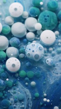 Dikey video. Sanat sıvısı. Tüylü yüzey. Mavi yuvarlak boya jeli yaratıcı akış soyut bir arka plan bırakır. Marbling odağını kaybetmiş renkli parçacıklar su dokusu.