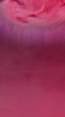 Dikey video. Bulanık boya sıçraması. Mürekkep rengi su. Odaklanmamış pembe parlak parlak sıvı damlalar soyut sanat ışığı arka planında sıvı buhar dokusu dalgası.