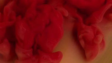 Mürekkep akışı. Boya karışımı. Odaklanmamış kırmızı kırmızı renk su dokusu akrilik parlak buhar soyut sanat yaratıcılığı arka planında yüzüyor..