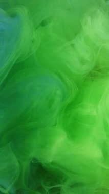 Dikey video. Boya bulutu. Renk dumanı. Odaklanmamış yeşil su altı buharı altın parıltı dokusuna yayılan hareket soyut sanat arkaplanı.