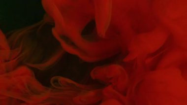 Canlı bir duman. Mürekkep atışı. Suyun altında kırmızı kıvrım pigmenti çözülür. Siyah arkaplan üzerine sisli sıvı parlak sprey. Odaklanamayan soyut akış.