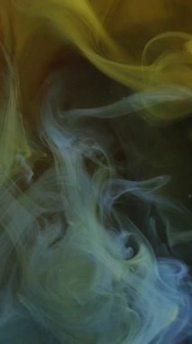 Dikey video. Boya bulutu. Renk dumanı. Odaklanamayan sarı su altı buharı altın parıltı dokusuna yayılıyor soyut sanat arkaplanı.