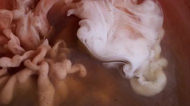 Akrilik sis. Mürekkep suyu. Pembe beyaz renkli duman dalgaları soyut yaratıcı arka planda yayılan parlak parçacıklar..