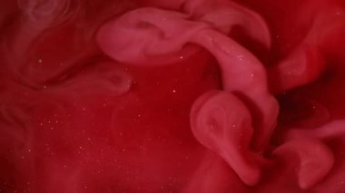 Mürekkep darbesi. Duman boyası. Kırmızı köpüklü suda pembe dalga pigmenti döküldü. Renk akışı çözünmüş boya soyut kıvrım arkaplanını çözer.