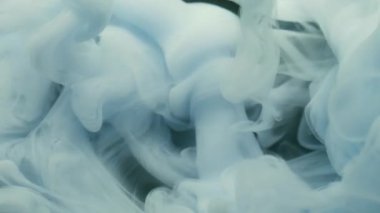 Boya bulutu. Buhar akışı. Beyaz mavi pigment sisi suda çözünür. Siyah bulanık arkaplanda sanat soyut kıvırcık dökülmüş mürekkep harmanı rengi.