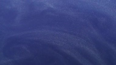Parıltı yayılıyor. Boya girdabı. Parıldayan sanat parçacıkları su tozu dökülüyor. Renk mavisi emülsiyon hareketi soyut arkaplan.