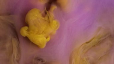 Harman damlası. Akan boya. Bulanık sarı mor duman buharı suyu nemlendirici sıvı soyut yaratıcı sanat arka planında yüzüyor..