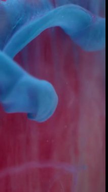 Dikey video. Mürekkep suyu girdabı. Görüntü yaratıcı duman. Odaklanmamış mavi renk parlaklık likit damlalar akışkan buhar doku dalgası soyut sanat arka planında.