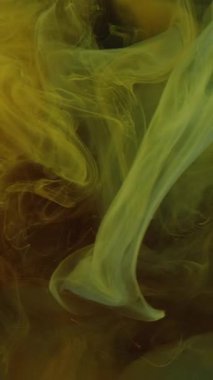 Dikey video. Boya sisi. Duman dokusu. Odaklanamayan sarı renkli sis dalgası kara soyut sanat arka planında yüzen su altı akış hareketi.