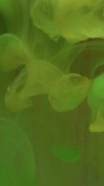 Dikey video. Sıvı boya akışı. Bulanık su mürekkebi. Odaklanmamış yeşil ışık, soyut ışık arkaplanına sis bulutu dokusu karışımı dalgası düşürür.