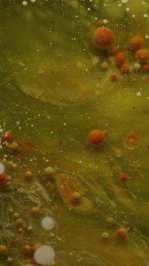 Dikey video. Mürekkep akışı. Yağ damlası akışı. Toz dokusu suyunda patlayan renkli mermer parçacıkları. Sanat emülsiyonu soyut duman arka planı dökülüyor.