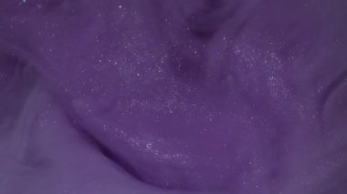 Kozmik mürekkep. Boyayla boyanmış. Fantezi bulutu suyun altında kaynaşıyor. Menekşe rengi parlatıcı pigmenti çözünmüş kıvrım akış arkaplanı.