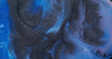 Mermer sıçraması. Renkli mürekkep dalgası. Odaksız mavi parlak pigment koyu siyah parçacıklar soyut akrilik canlı arkaplan üzerine dökülür.