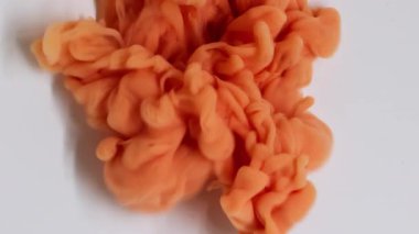 Mürekkep dalgası. Sigara arkaplanı. Odaklanmamış turuncu bronz renk su püskürtme parçacıkları beyaz sanatın ıslak soyutlamasına yayılıyor..