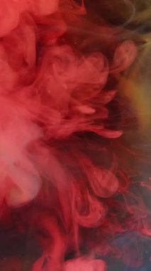 Dikey video. Patlama bulutu. Sıcak duman. Odaklanmamış kırmızı renk dumanı deseni mürekkep damlası koyu soyut sanat arka planında hareketi gösterir.