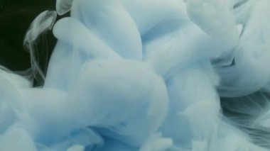 Duman karışımı. Buhar mürekkebi. Siyah arkaplana yayılan beyaz mavi sıvı girdap. Yüzen su altında bulanık renk soyut kontrast pigmenti.