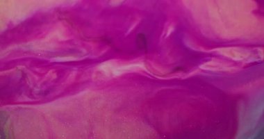 Bulanık boya sıçraması. Parlak pigmentler. Soyut arkaplana yayılan mor pembe altın renkli simli partiküller..