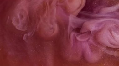 Parlak dumanlı sıvı. Parıldayan sanat. Odaklanmamış turuncu mor renkli boya soyut arka planda yayılan su dumanı akışında dönüyor..