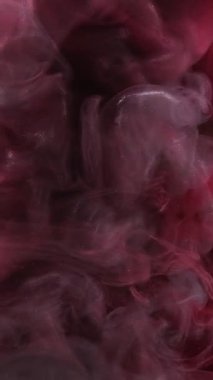 Dikey video. Parıldayan duman. Mürekkepli su sıçraması. Odaklanmamış pembe renkli parlak desenli sis perdesi yayılan girdap hareketli soyut sanat arkaplanı.