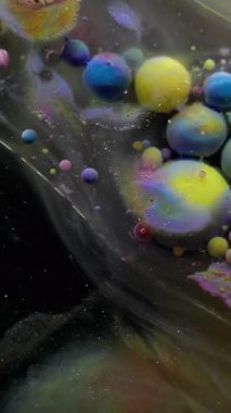 Dikey video. Mermer yağ damlası. Duman sıvısı. Yüzeyde hareket eden şeffaf lekeli jel baloncukları. Renkli köpük soyut arkaplan