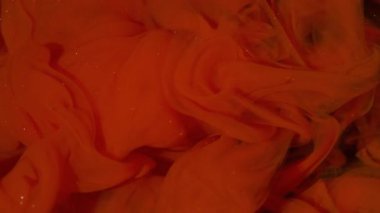 Buhar karışımı. Sis mürekkebi kıvrılıyor. Sanatın içindeki kırmızı boya çözünmüş sıvıya karışıyor. Hipnotik ışıltılı akış rengi kıvrımlı soyut siyah arkaplan.