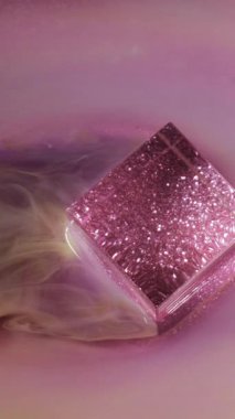 Dikey video. Işıl ışıl parlıyor. Parlak parlak boya. Parlak sarı akış dumanı parıldayan küp kübü mürekkep dokusu sanat ışığı arka planında yüzüyor.