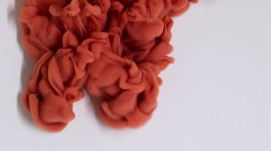 Duman sıvısı. Akış yayılıyor. Odaklanmamış turuncu bronz boya soyut beyaz arka planda su buharı sıvısında kıvrılır..