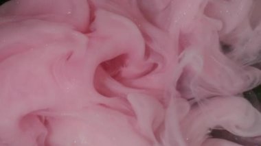 Buhar karışımı. Sis mürekkebi kıvrılıyor. Sanatta karıştırılmış pembe beyaz boya çözünmüş sıvı. Hipnotik ışıltılı akış rengi kıvrımlı soyut siyah arkaplan.