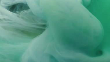 Boya fırıldağı. Dalga sisi. Akışkan mürekkep fantazisi renkli su altı girdabı. Mavi yeşil soyut kimya sıçraması odaklanmış arkaplan.