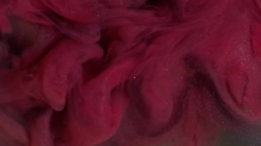 Parlak dalga. Mürekkebi karıştır. Odaklanmamış pembe mor renkli su. Soyut karanlık sanat arka planında parlayan parçacıklar..