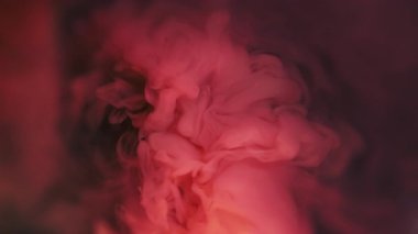 Dönen sıvı. Arkaplanı boya. Odaklanmamış pembe renk, parıltılı sıvı koyu siyah yaratıcı soyutlamaya yayılıyor..