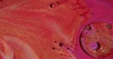 Yağ sıvısı. Mürekkep sıçraması. Odaklanmamış pembe renk akışı parlak sıvı köpük soyut yaratıcı arka planda yayılıyor.