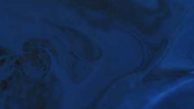 Mürekkep lekeleri. Karışım akışı. Odaklanamayan mavi renkli parlak su mermeri, soyut sanat üzerine hareket eden kimyasal dokuları kıvılcım saçar..