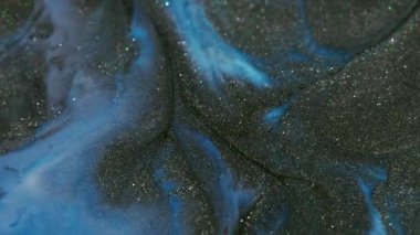 Parlak doku. Renkli mürekkep dalgası. Odaklanamayan mavi parlak pigment koyu siyah parçacıklar soyut akrilik sanat yaratıcı arka plana dökülüyor.