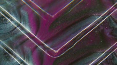 Mürekkep açısı. Akrilik sıçrama. Odaklanamayan mor neon renkli parlak koyu siyah parçacıklar soyut sanat arka planında yayılıyor..