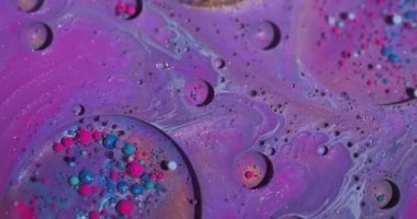 Boya baloncukları. Boya dalgası. Soyut sanat arka planında yüzen pembemsi mavi damlacık yağ akrilik sıvısı.