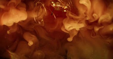 Su altı dumanı. Bulanık ışık parlıyor. Aydınlatılmış cam çelenk soyut renk sıçraması. Koyu parlak arka planda kırmızı turuncu bulut mürekkebi akıyor.