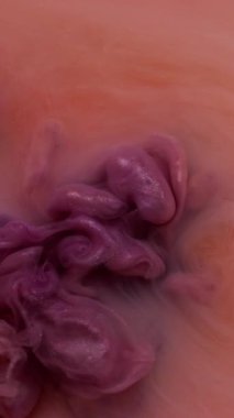 Dikey video. Mürekkep suyu. Boya karışımı. Odaklanmamış pembe turuncu renkli duman girdap dokusu sıvı sıvısı soyut sanat arka planına yayılıyor.