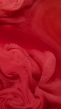 Dikey video. Duman boyası. Fış sanatı. Soyut arkaplanda yüzen akrilik su karışımı sisli, pembemsi kırmızı kırmızı sıvı doku..