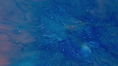 Parlak serpinti. Mavi mürekkep dalgası. Odaklanmamış pembe parlak pigment ıslak parçacıklar soyut akrilik canlı yaratıcı arka plana dökülüyor.