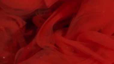 Buhar karışımı. Sis mürekkebi kıvrılıyor. Sanatın içindeki kırmızı boya çözünmüş sıvıya karışıyor. Hipnotik ışıltılı akış rengi kıvrımlı soyut siyah arkaplan.