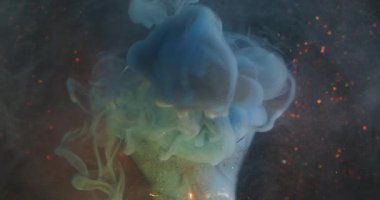 Su altı dumanı. Bulanık ışık parlıyor. Aydınlatılmış cam çelenk soyut renk sıçraması. Koyu parlak arka planda mavi turuncu bulut mürekkebi akıyor.