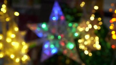 Yıldız şeklinde yanıp sönen Noel ışıklarının bulanık arkaplanı. Yakından çekilen renkli noel resmi mavi, kırmızı ve sarı renkli LED ışıklar.