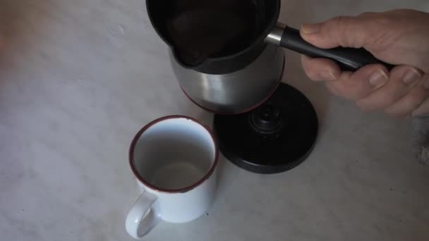 Hand Schenkt Turkse Koffie Uit Elektrische Koffiewaterkoker Witte Keramische Beker — Stockvideo