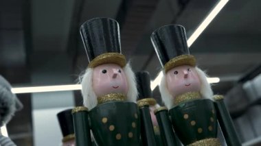 Fındıkkıran ahşap bebekler yeşil kostümler içinde altın detaylarla modern binaların üzerinde duruyor arka planda doğrusal ışıklarla duruyor. Noel Fındıkkıran oyuncak bebeklerinin çekimleri..