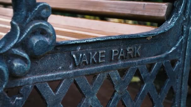 Vake Parkはヴィンテージスタイルのパークベンチの金属の詳細にレタリングをエンボスし パンニングショットを閉じました — ストック動画