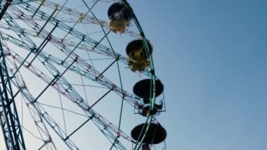 Eski Sovyet tarzı dönme dolap silueti gece boyunca mavi gökyüzü arka planında dönüyor..