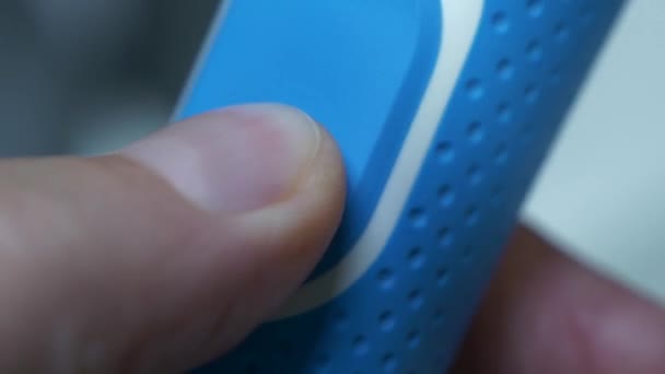 青い電気歯ブラシの電源ボタンの機能を示し その応答性と使いやすさを示す指のクローズアップビデオ — ストック動画
